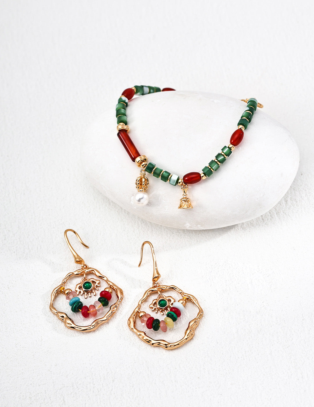 A detailed view of the Iris collection set, showcasing the organic textures of the pearls and gemstones across the bracelet and earring combination.
