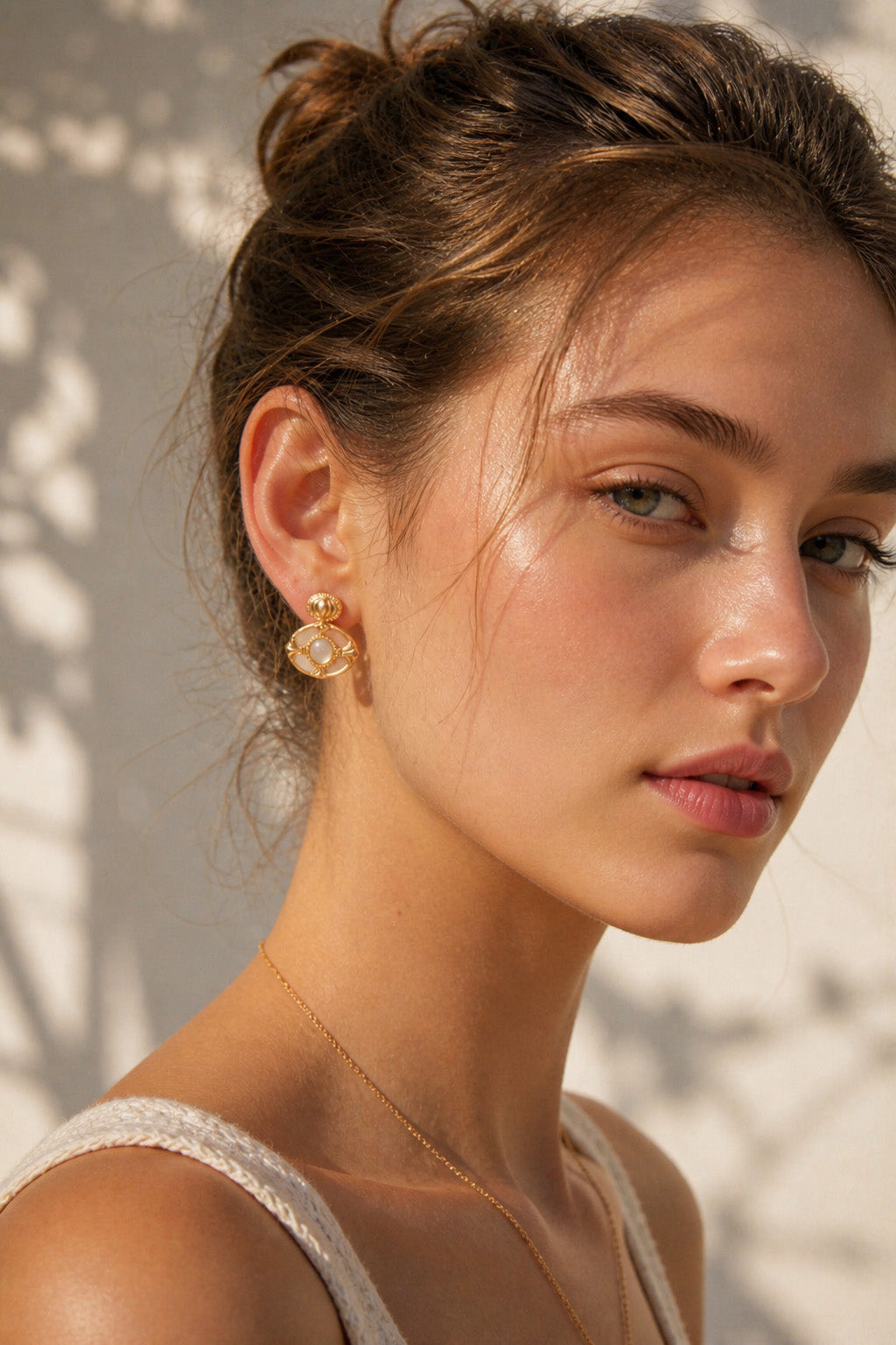 A lifestyle shot of the Artemis green chalcedony studs worn by a model. The visual highlights the intricate golden frame and how the verdant gemstone adds a luxurious, vintage-inspired focal point to the ear.