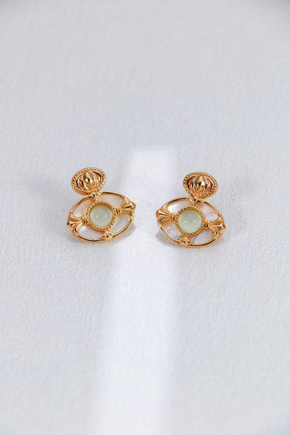 A professional studio shot of the Artemis earrings, showcasing the high-polish finish of the Green Chalcedony and the creamy, shifting luster of the Mother-of-Pearl border.