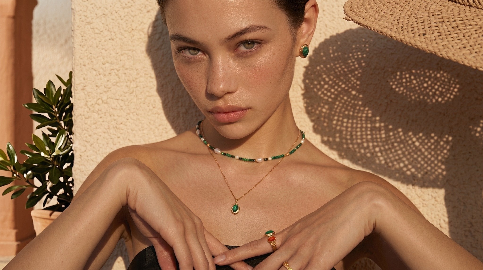 Sunlit model wearing freshwater pearl and green gemstone necklace, quiet luxury jewelry with natural elegance by VÉRA LUSTRE