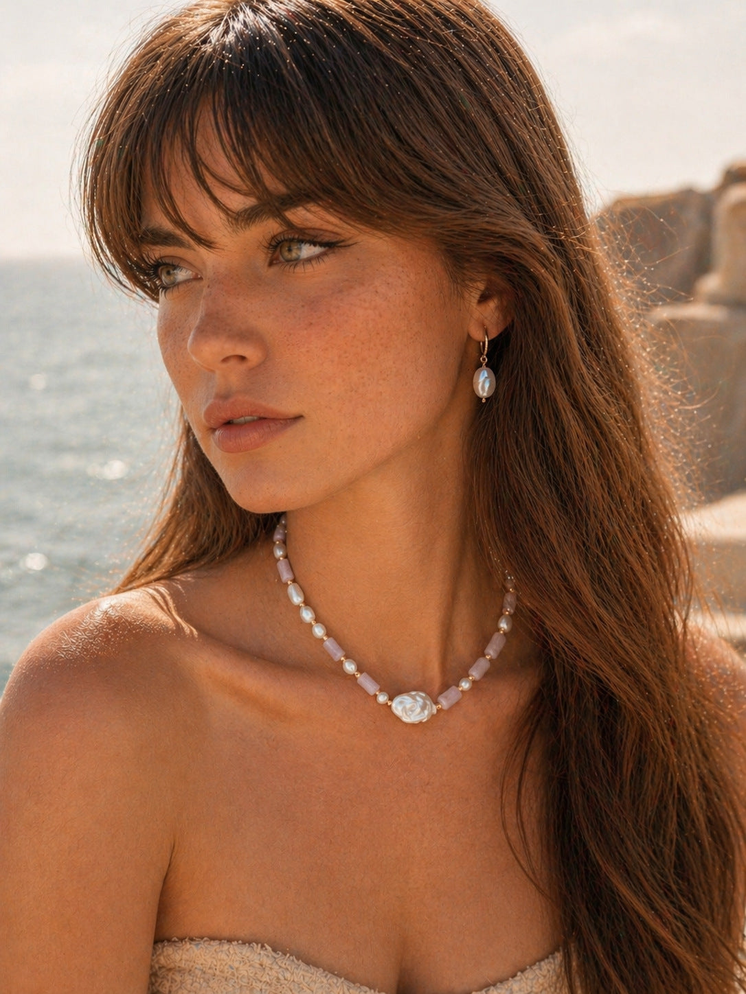 A lifestyle shot of the Amoris lepidolite necklace worn at a 38cm collar length. The image highlights the soft purple tones of the healing stones and the iridescent glow of the baroque pearls against the skin, showcasing its "feminine energy" appeal for daily wear.