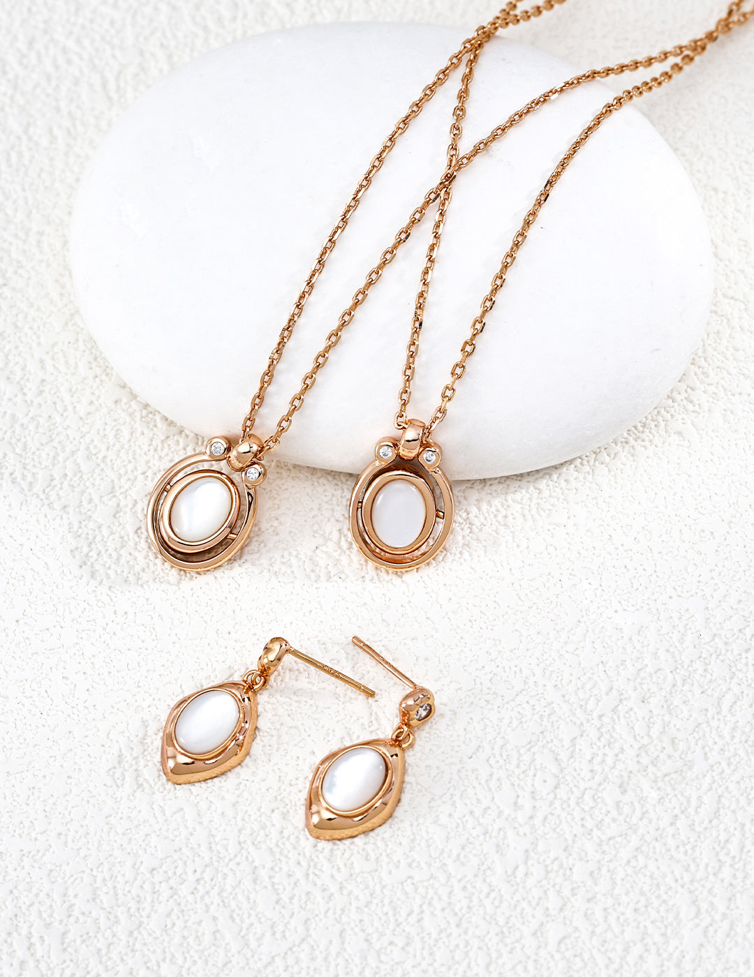 A crisp display of the Astra Mother of Pearl jewelry set, featuring the iridescent white shell inlay in both the necklace and matching pieces. The soft glow of the natural white shell is contrasted by a halo of sparkling cubic zirconia, emphasizing the premium S925 sterling silver craftsmanship and a clean, luxury aesthetic.