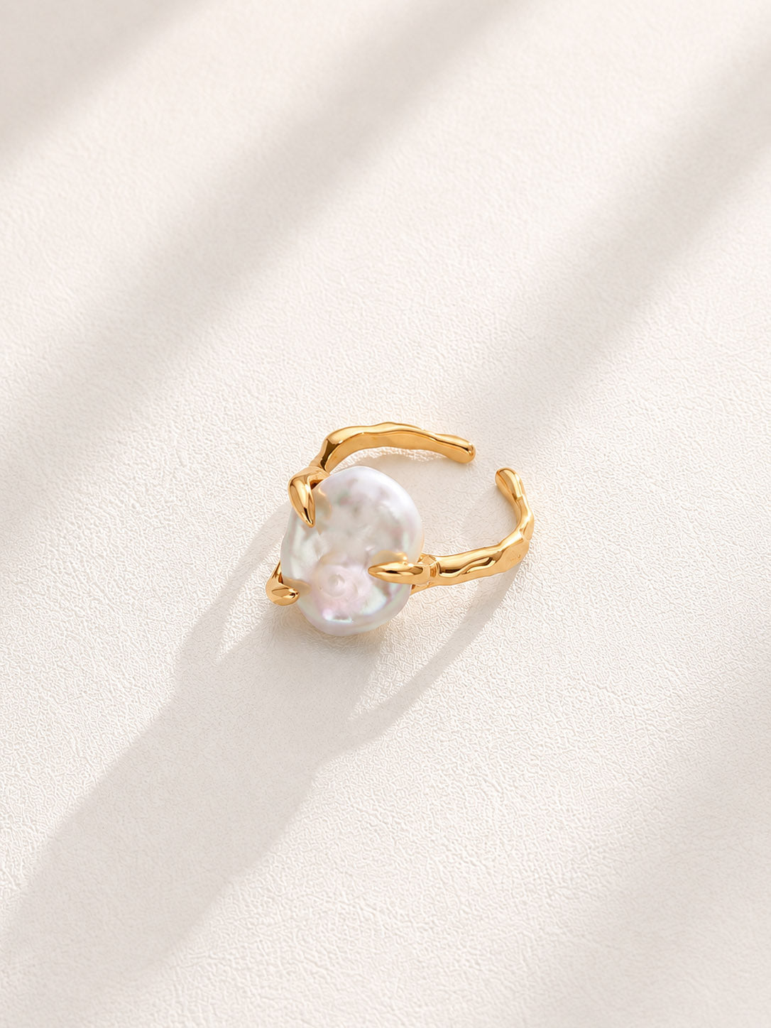 Vera Lustre "Aura" statement ring featuring a large, iridescent baroque pearl on an adjustable 18K gold vermeil fluid band.