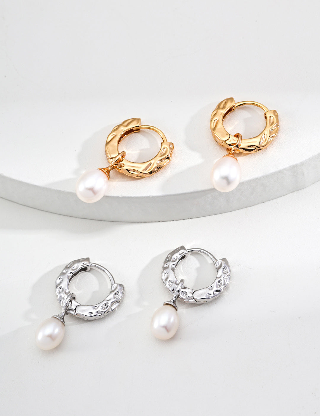 A macro shot focusing on the transition between the etched metal bark and the pearl setting in both gold and silver, targeting customers seeking nature-inspired fine jewelry.