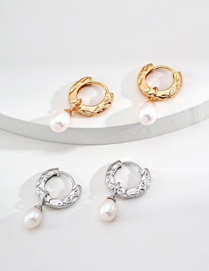 A macro shot focusing on the transition between the etched metal bark and the pearl setting in both gold and silver, targeting customers seeking nature-inspired fine jewelry.