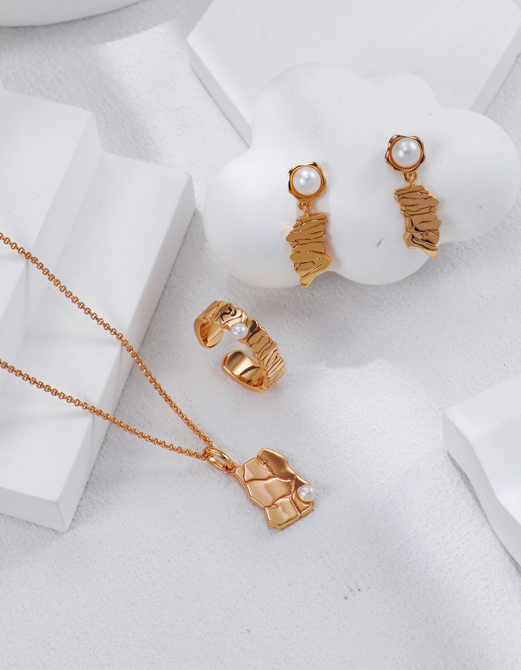 A curated flat lay of the Eirene earrings alongside a matching textured gold necklace, emphasizing a cohesive vintage-inspired jewelry set for conscious collectors.