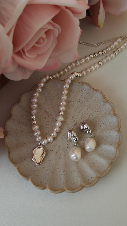 A curated flat lay of the Serene jewelry set, showcasing the matching pearl necklace and fluid-style accessories. This visual targets searchers looking for coordinated silver jewelry sets that offer a cohesive, water-inspired aesthetic for special occasions or daily luxury.
