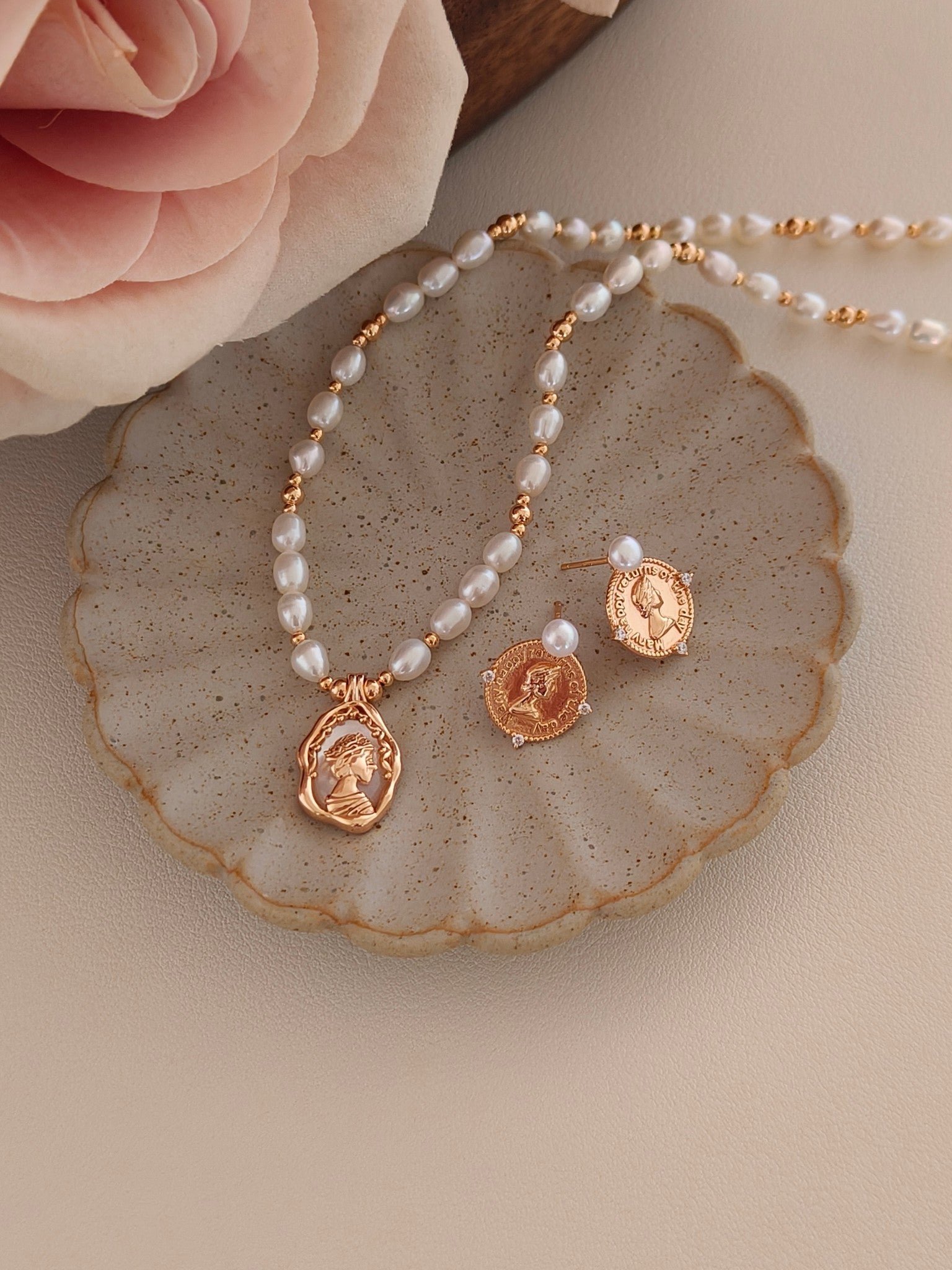 A detailed macro shot of the 4-5mm natural pearls, showcasing their high-luster surface and consistent shape. The focus on the vintage gold medallion relief reinforces the product's premium value and its status as a durable, hypoallergenic accessory for sensitive skin.