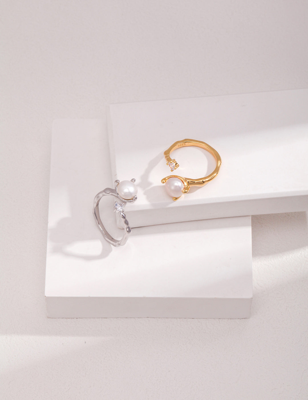 A high-contrast display of both the Gold and Silver Elora rings, illustrating the harmony of the mixed-metal collection for versatile styling.