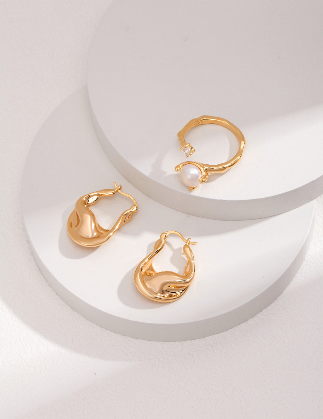 A captivating studio composition of the Elora jewelry suite, showcasing the flawless coordination between the zircon-encrusted pearl ring and the matching shimmering drop earrings, embodying a complete look of modern celestial elegance.