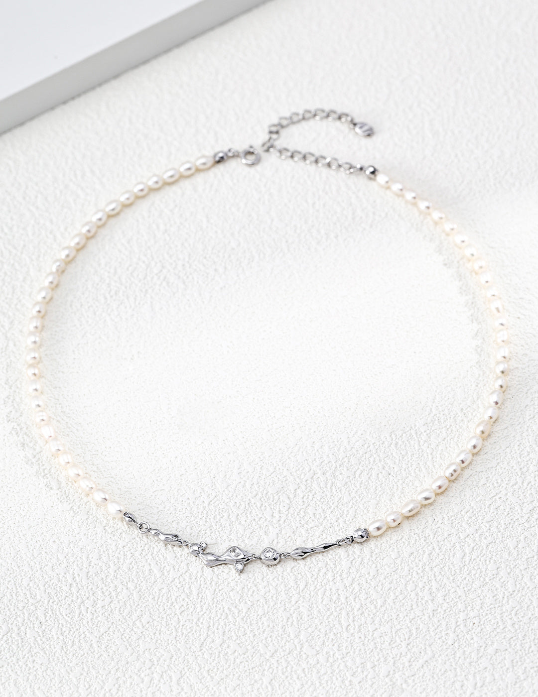 A clean product shot of the Astra necklace in platinum white gold tone. This view emphasizes the cool, modern brilliance of the silver and the high-luster pearls, targeting customers looking for celestial-themed silver jewelry.