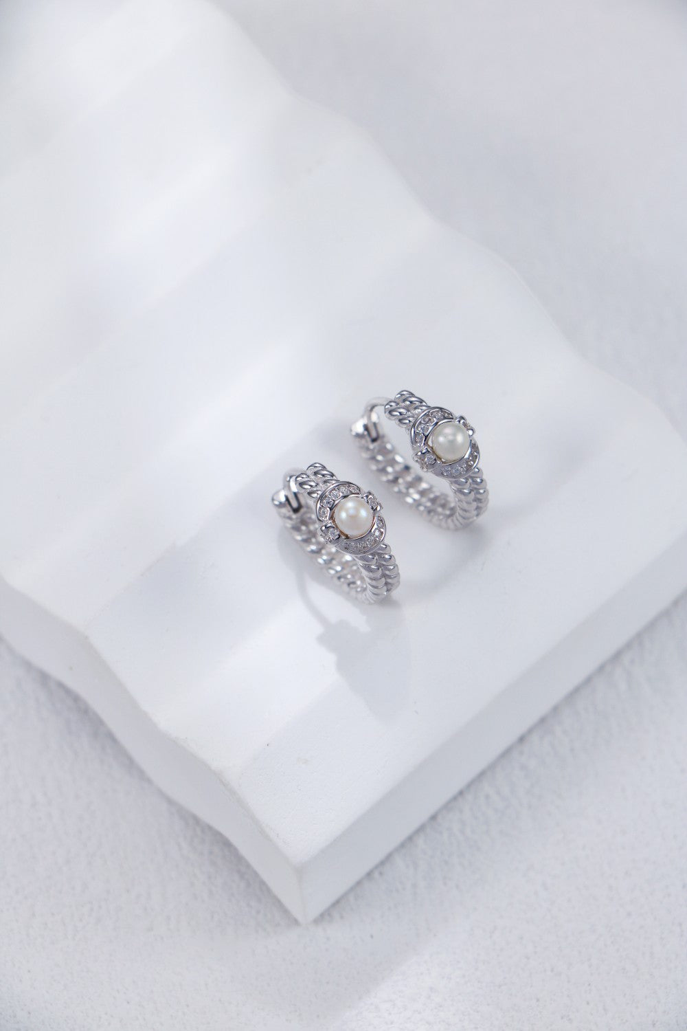 A side view focusing on the smooth, tapering metalwork and the secure, integrated hook design of the sterling silver pearl drops.