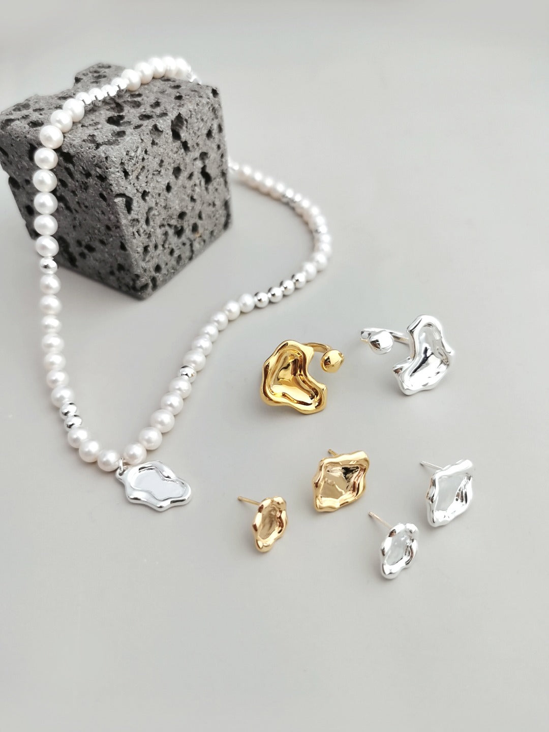 A curated flat lay of the Serene jewelry set, showcasing the matching pearl necklace and fluid-style accessories. This visual targets searchers looking for coordinated silver jewelry sets that offer a cohesive, water-inspired aesthetic for special occasions or daily luxury.