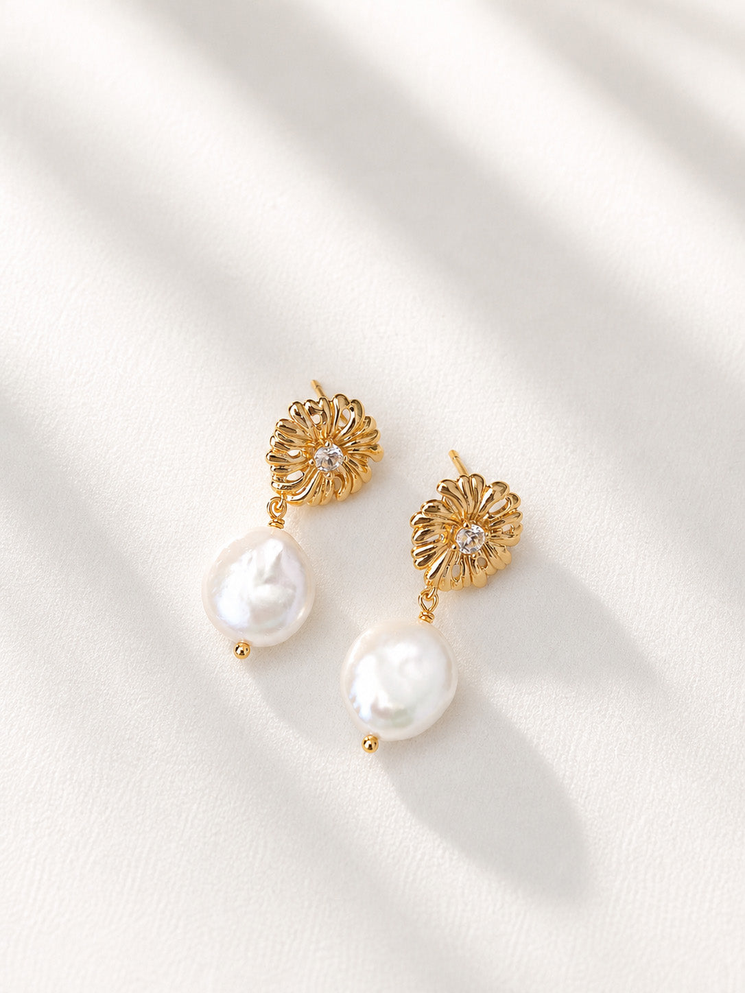 A professional studio shot of the Soleil earrings, showcasing the intricate sunflower design and the thick, lustrous baroque pearl drops. This image emphasizes the vintage gold S925 silver craftsmanship.