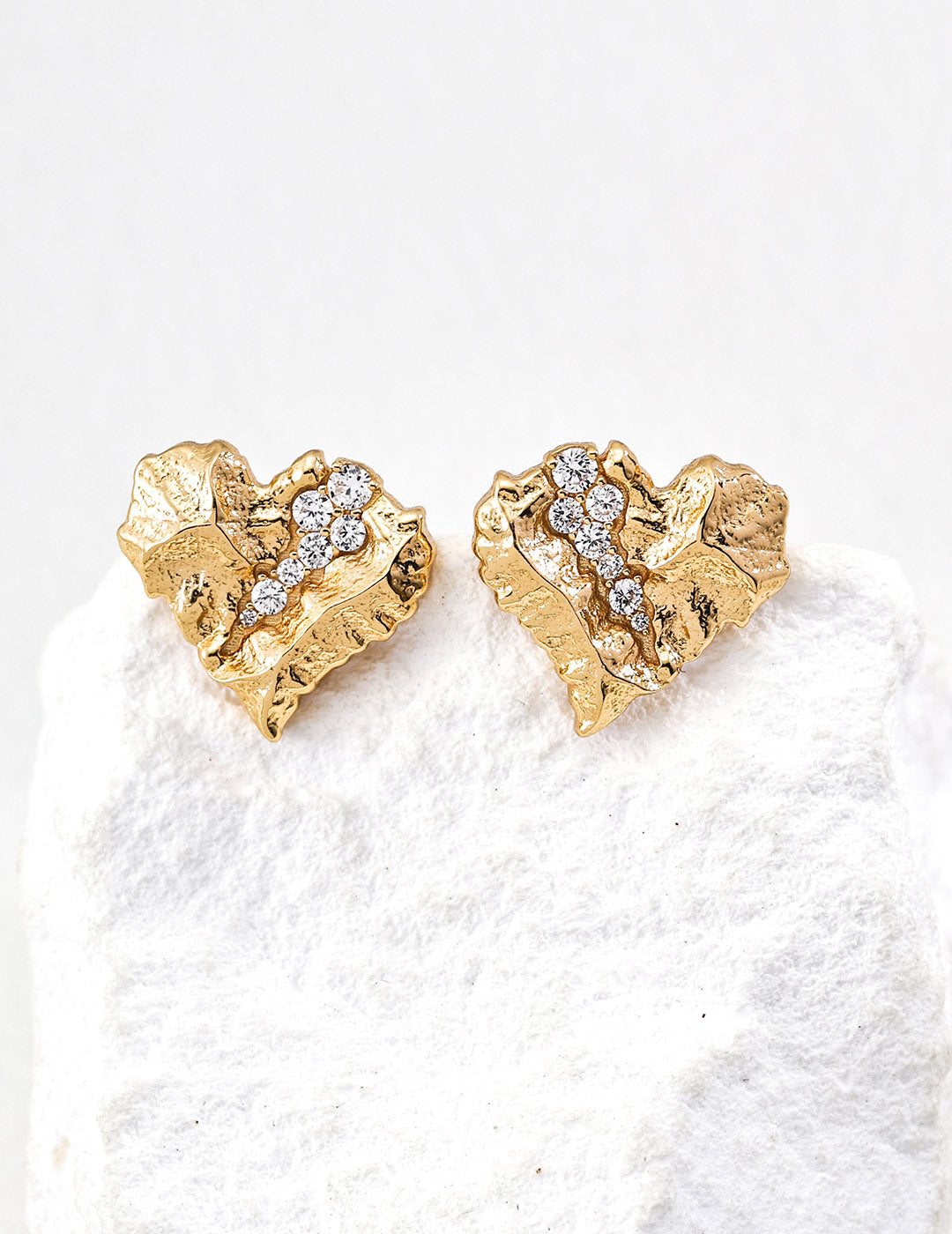 A clean studio shot of the Kardia earrings, showcasing the unique heart silhouette and the "gemstone crystallization" effect within the textured fissures.