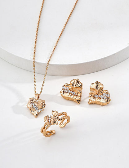 A lifestyle arrangement of the heart earrings alongside other gold accessories, showcasing their versatility for modern romantic styling.