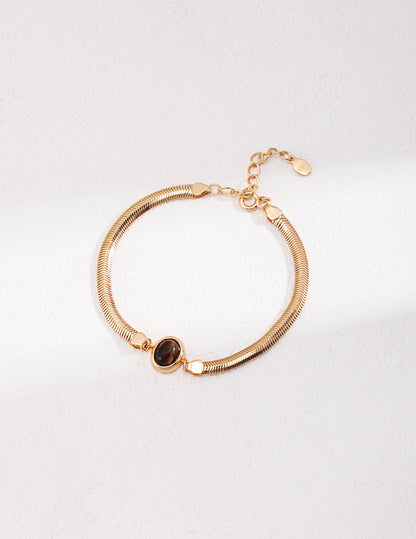 A professional studio shot of the Cyra bracelet in Vintage Gold, highlighting the warm, antique-inspired bezel setting that enhances the earth tones of the stones.