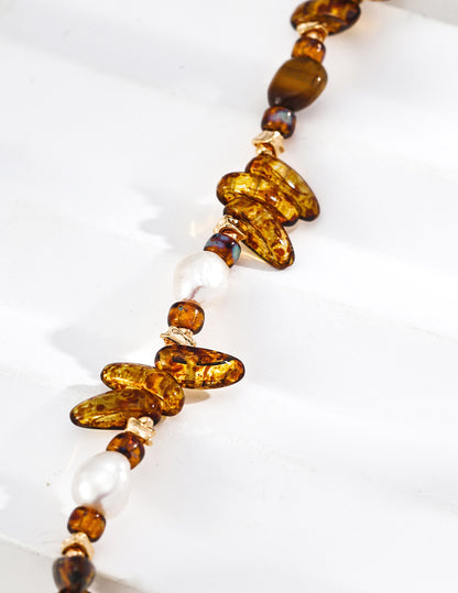 A macro close-up focusing on the Tiger's Eye's silky luster and the unique textures of the artisanal glass, emphasizing the high-quality natural materials used.