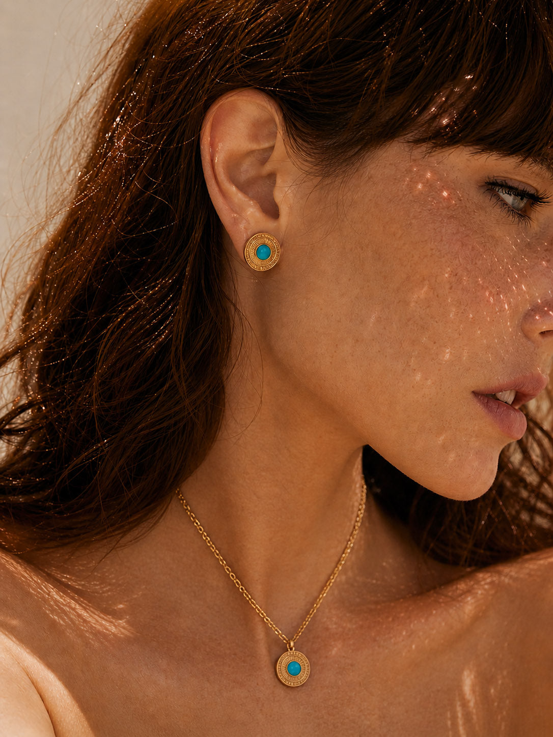 A lifestyle shot of the Jadeite drop earrings worn by a model. The visual demonstrates the graceful sway of the natural jade stones and how the 18K gold finish adds a warm, sun-kissed glow to a sophisticated daytime look.