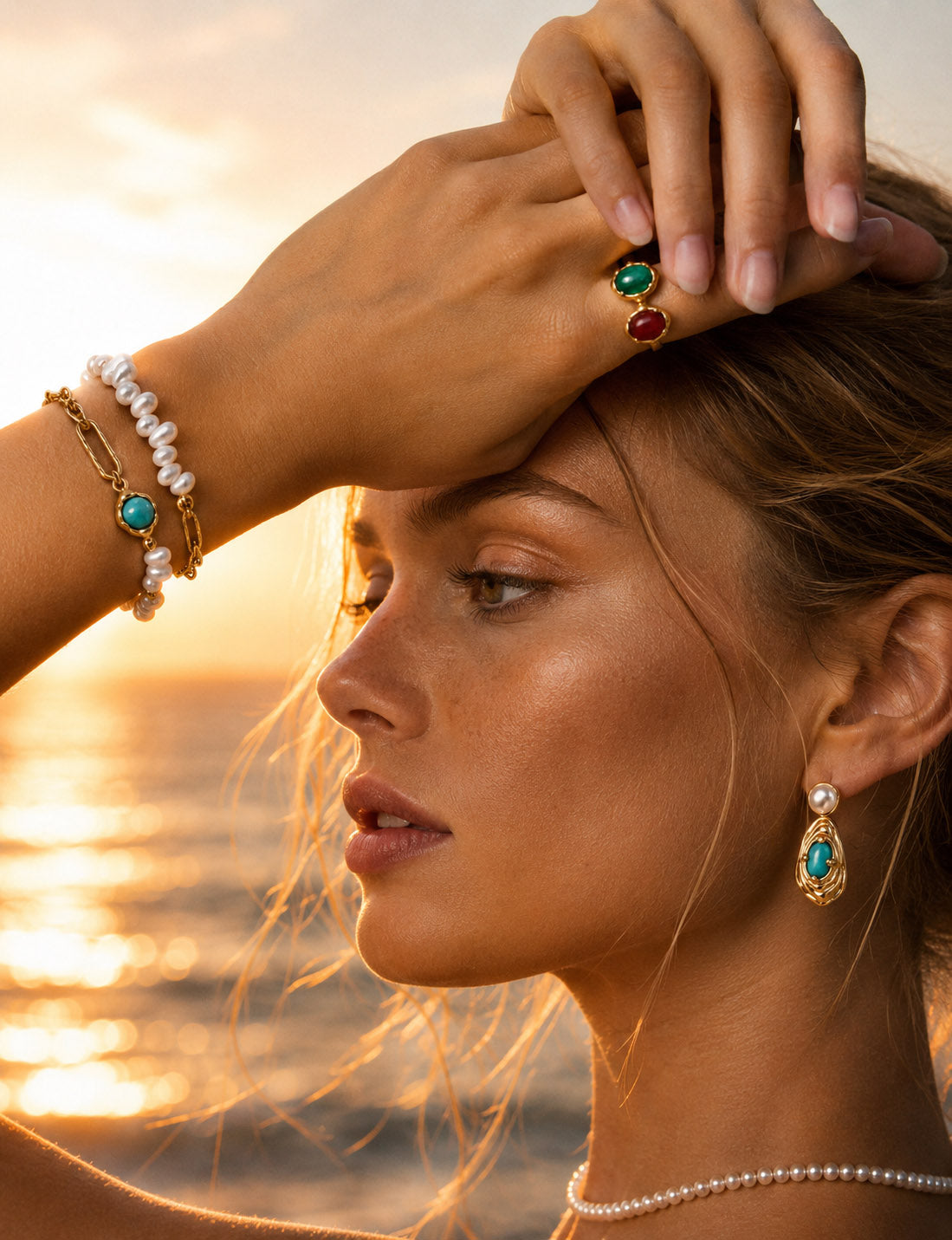 A lifestyle shot of the Holly turquoise pearl bracelet styled with a silk cuff, showcasing its delicate vintage proportions and vibrant blue focal points.