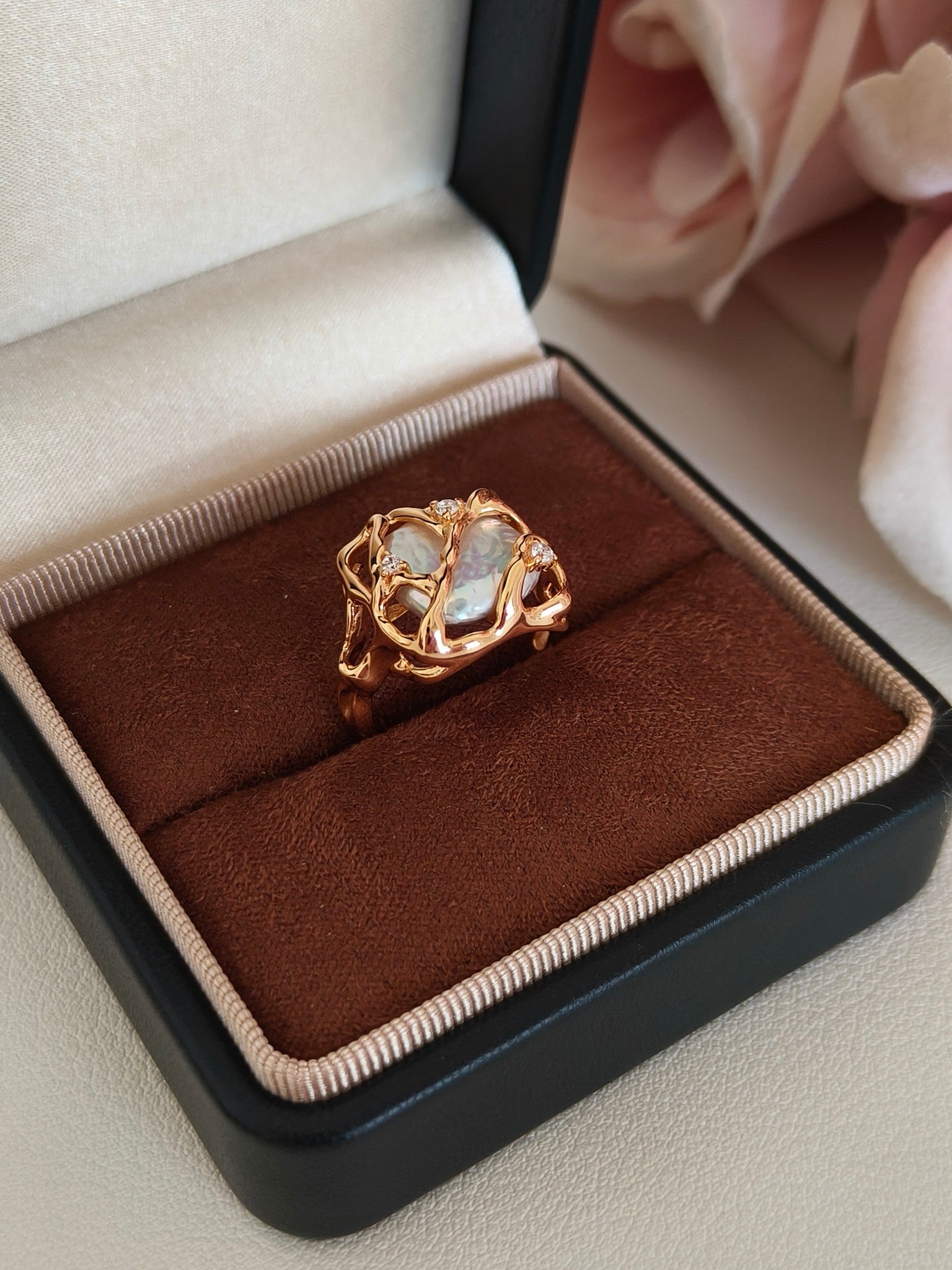 The Vera Lustre Terra baroque pearl ring presented in a premium jewelry box, highlighting its architectural gold detailing and iridescent luster.